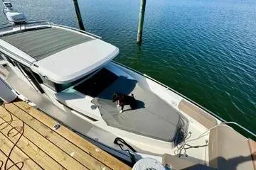 Slide: The Image of 2018 Axopar 37 XC CROSS CABIN boat docked with a dog on deck. - 3
