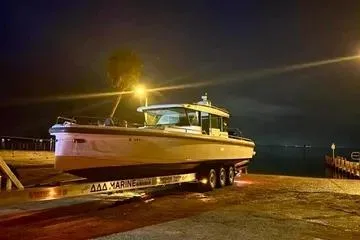 Slide: The Image of 2018 Axopar 37 XC CROSS CABIN boat on trailer at night by the water. - 9