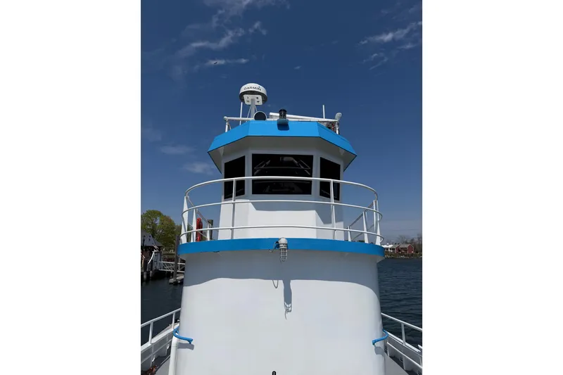 Slide: The Image of 1954 American 70 Tugboat with blue accents under clear sky. - 11