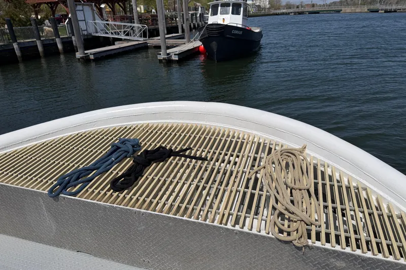Slide: The Image of Bow of 1954 American 70 Tugboat with ropes, docked in calm waters. - 13