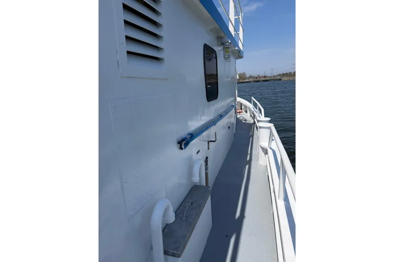 Slide: The Image of Side view of a 1954 American 70 Tugboat on calm water. - 16