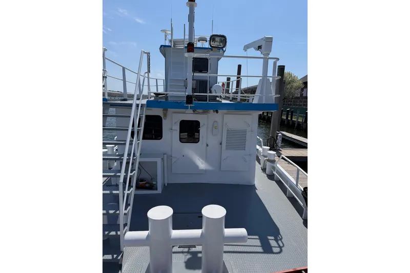 Slide: The Image of 1954 American 70 Tugboat docked, featuring upper deck and railing. - 19