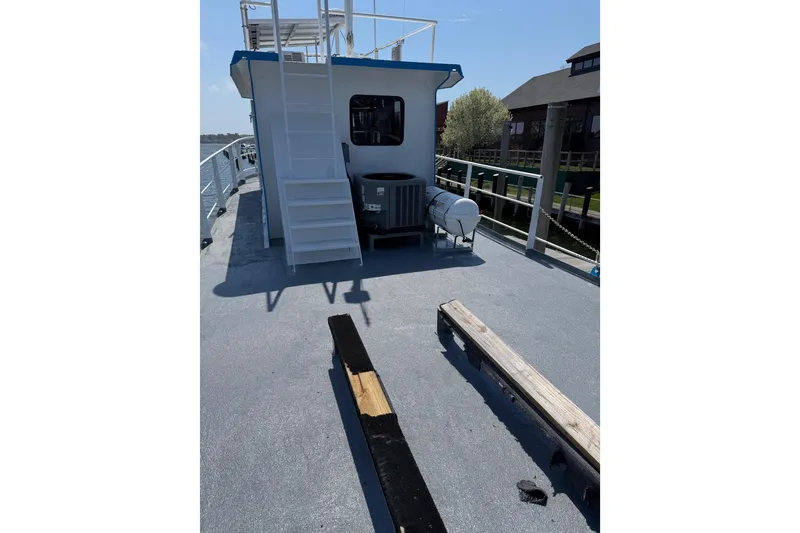Slide: The Image of 1954 American 70 Tugboat deck with stairs and equipment, docked near buildings. - 20