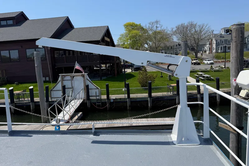 Slide: The Image of White crane on a 1954 American 70 Tug boat docked near wooden buildings. - 21