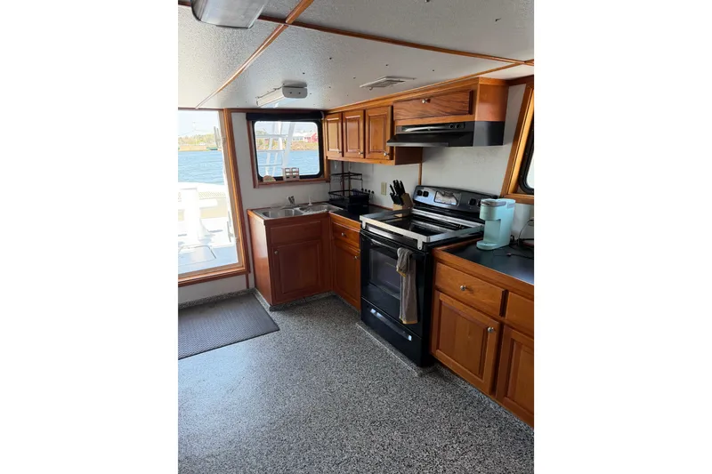 Slide: The Image of Kitchen interior of a 1954 American 70 Tug boat with wooden cabinets and modern appliances. - 29