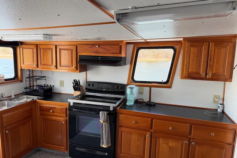 Slide: The Image of Interior of a 1954 American 70 Tug boat kitchen with wooden cabinets and modern appliances. - 30