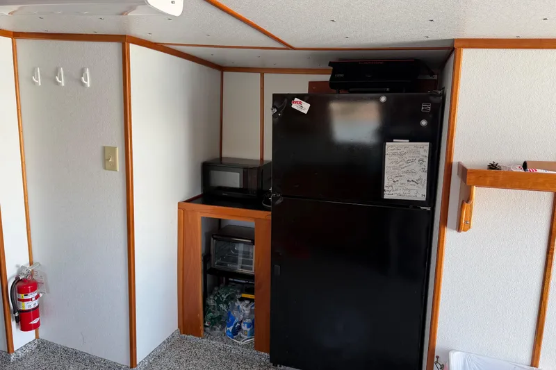 Slide: The Image of 1954 American 70 Tug interior with black fridge, microwave, and fire extinguisher. - 31