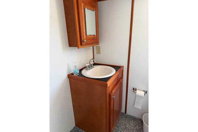 Slide: The Image of Wooden bathroom vanity with sink and mirror on a 1954 American 70 Tug. - 33
