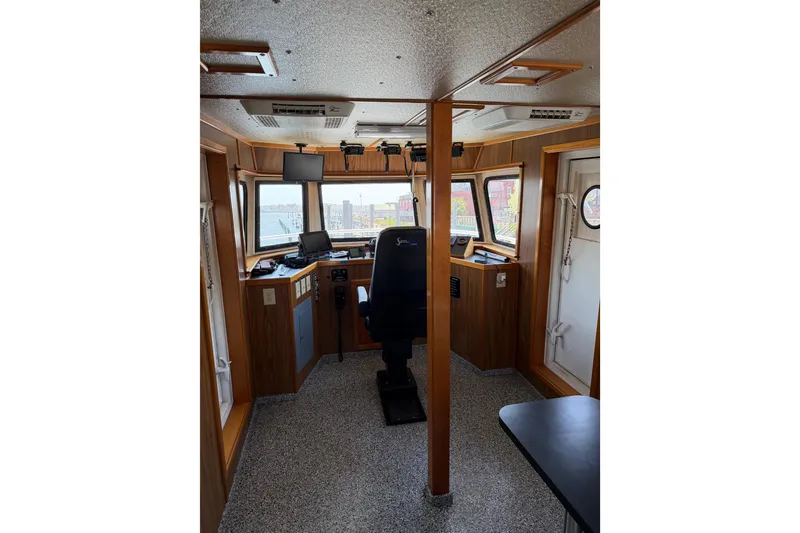 Slide: The Image of 1954 American 70 Tugboat interior with wooden paneling and navigation equipment. - 38