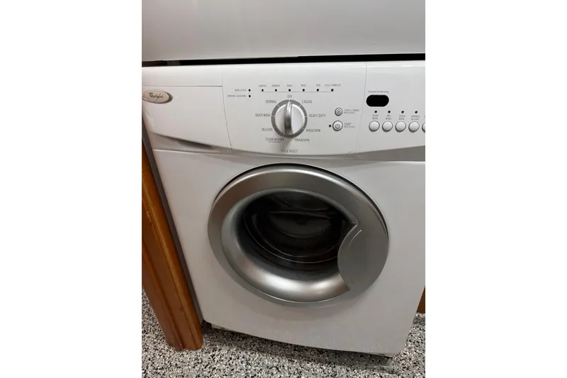 Slide: The Image of Front-loading washing machine with control panel, Whirlpool brand, on a speckled floor. - 56