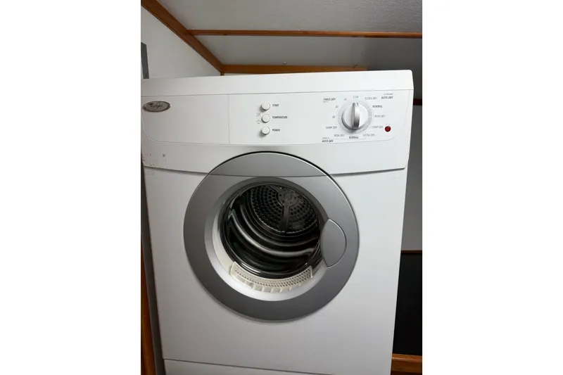 Slide: The Image of White front-loading washing machine with control knobs, in a wooden-framed laundry area. - 57
