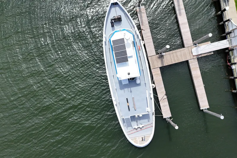 Slide: The Image of Aerial view of a 1954 American 70 Tugboat docked at a marina. - 6