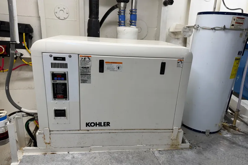 Slide: The Image of Kohler generator in a 1954 American 70 Tug engine room, surrounded by pipes and equipment. - 67