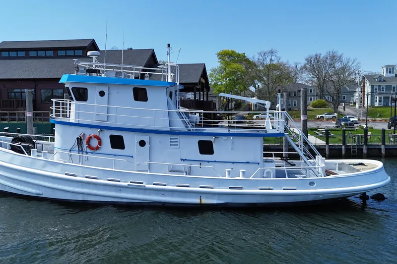 Slide: The Image of 1954 American 70 Tugboat docked by waterfront buildings. - 7