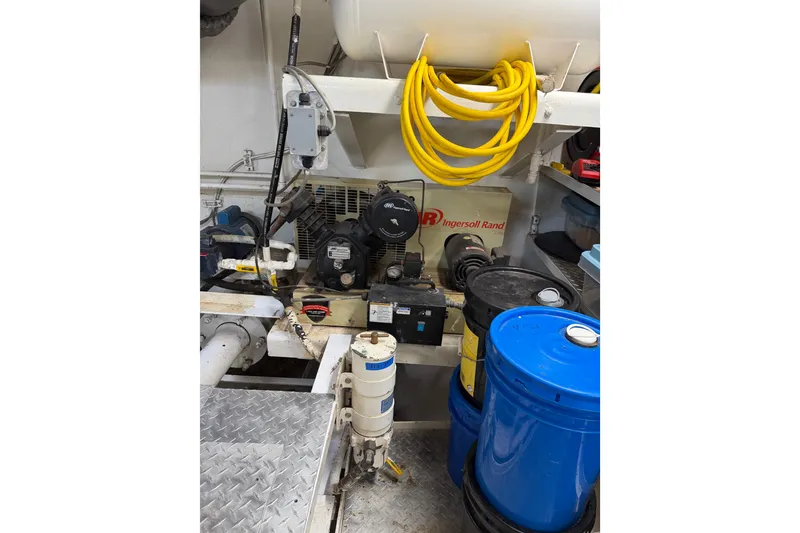 Slide: The Image of Engine room of a 1954 American 70 Tug with equipment and storage barrels. - 70