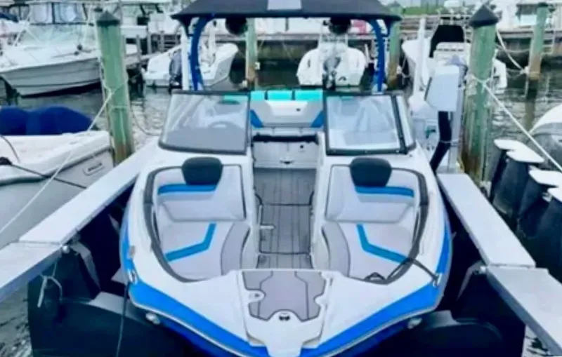 Slide: The Image of 2019 Yamaha Boats 242X E-Series docked, featuring sleek design and spacious seating. - 9