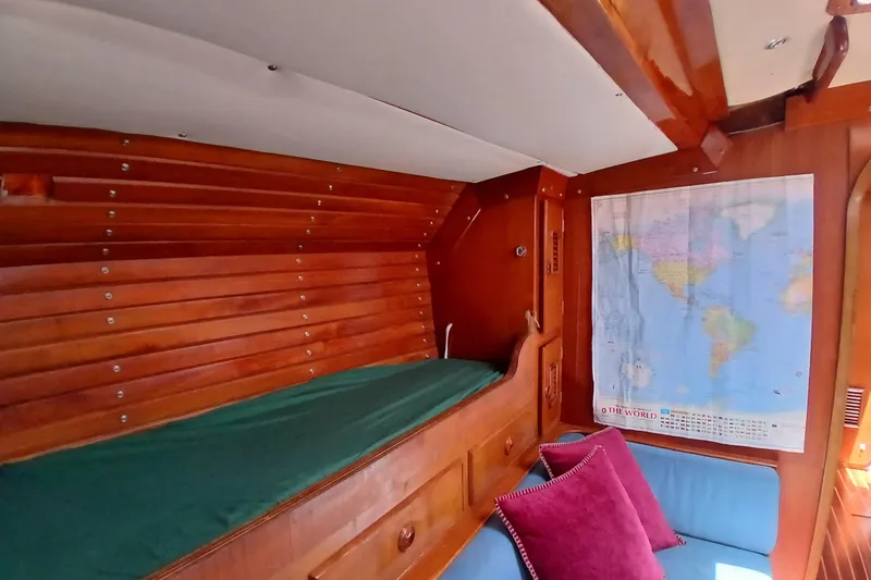 Slide: The Image of Interior of 1981 SKYE 51 yacht with wooden paneling, world map, and cozy seating. - 14