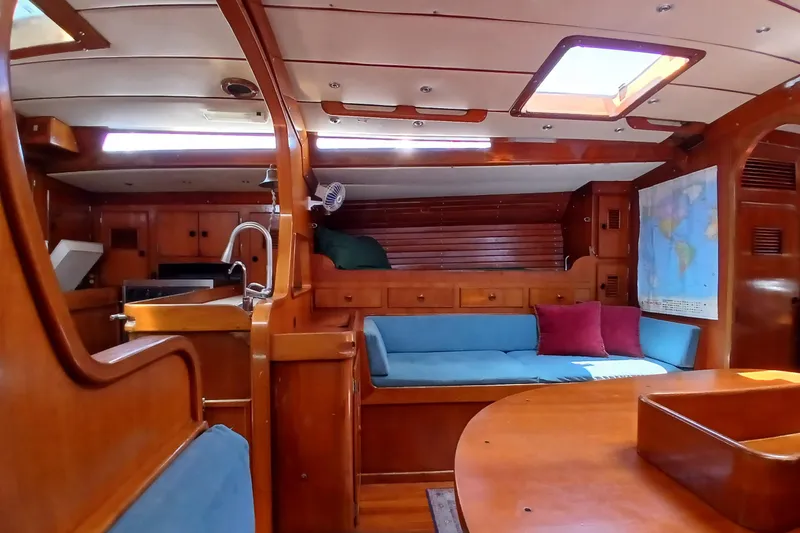 Slide: The Image of Interior of 1981 SKYE 51 yacht with wooden furnishings and blue seating. - 16