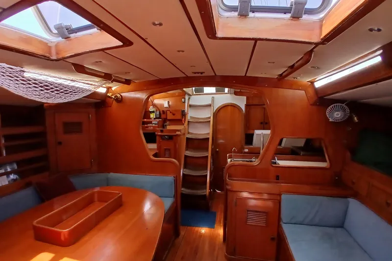 Slide: The Image of Interior of a 1981 SKYE 51 yacht with wooden furnishings and blue seating. - 19