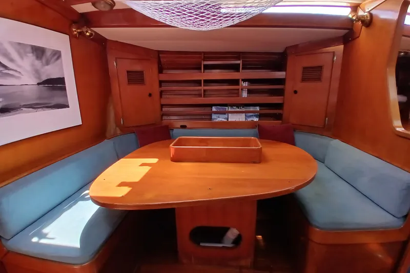 Slide: The Image of Cozy 1981 SKYE 51 yacht interior with wooden dining area and blue seating. - 20