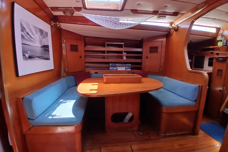 Slide: The Image of Interior of 1981 SKYE 51 yacht with wooden dining area and blue cushioned seating. - 21