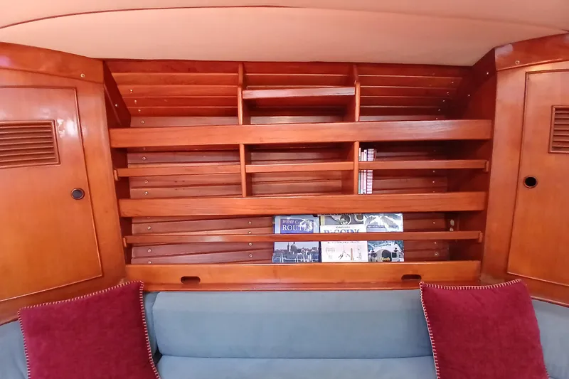 Slide: The Image of Wooden interior shelving on a 1981 SKYE 51 yacht, featuring books and red cushions. - 22