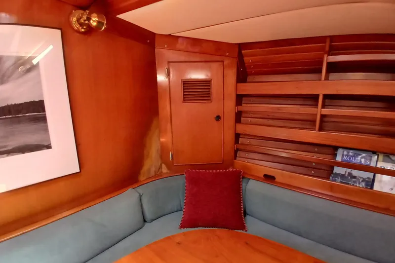Slide: The Image of Cozy wooden yacht interior with cushioned seating, bookshelf, and framed artwork, SKYE 51, 1981. - 23