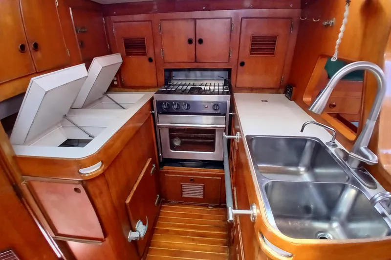 Slide: The Image of Vintage 1981 SKYE 51 yacht kitchen with wooden cabinetry and stainless steel sink. - 27
