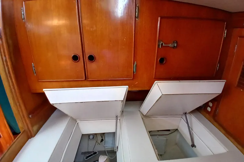 Slide: The Image of Wooden cabinets and open storage compartments in a 1981 SKYE 51 boat interior. - 28