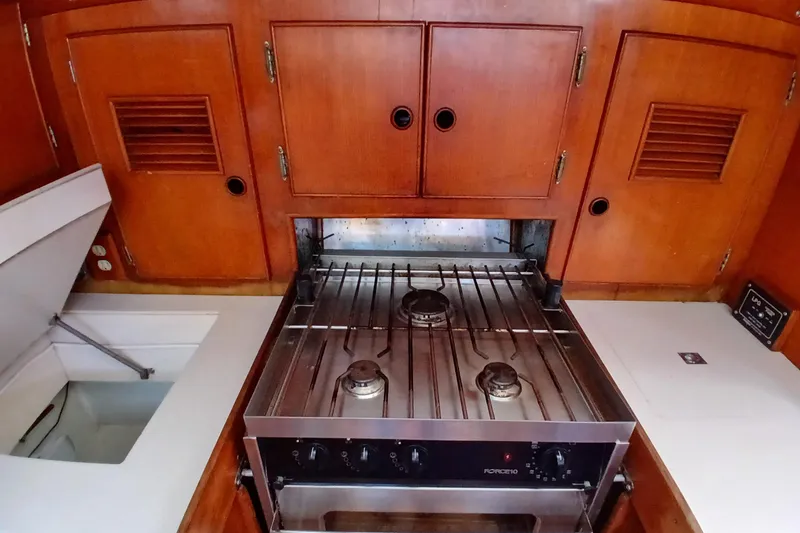 Slide: The Image of Vintage 1981 SKYE 51 yacht kitchen with wooden cabinets and a three-burner stove. - 29