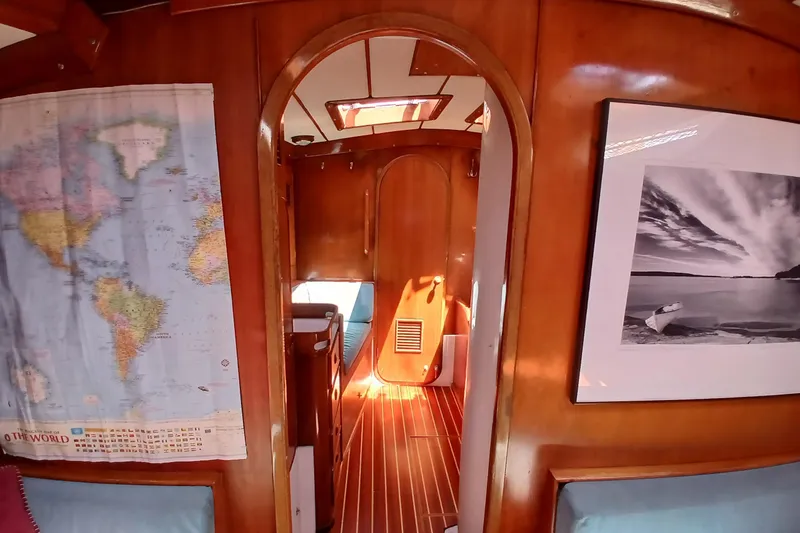 Slide: The Image of Interior of 1981 SKYE 51 yacht with wooden paneling, world map, and framed photograph. - 33