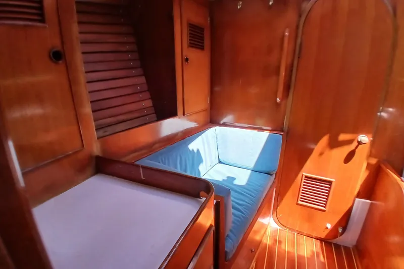 Slide: The Image of Interior of 1981 SKYE 51 yacht with wooden paneling and blue cushioned seating. - 34