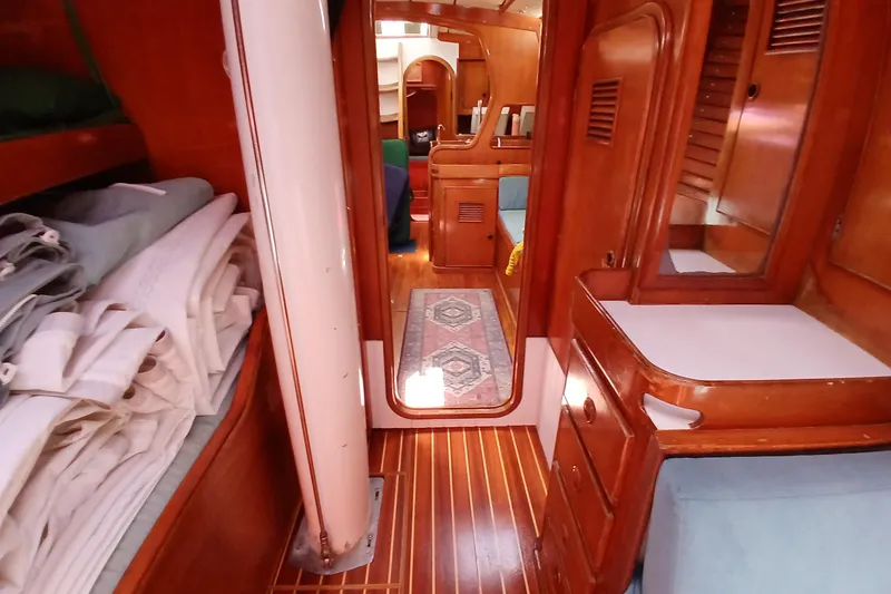 Slide: The Image of Interior of 1981 SKYE 51 sailboat with wooden cabinetry and neatly folded linens. - 35