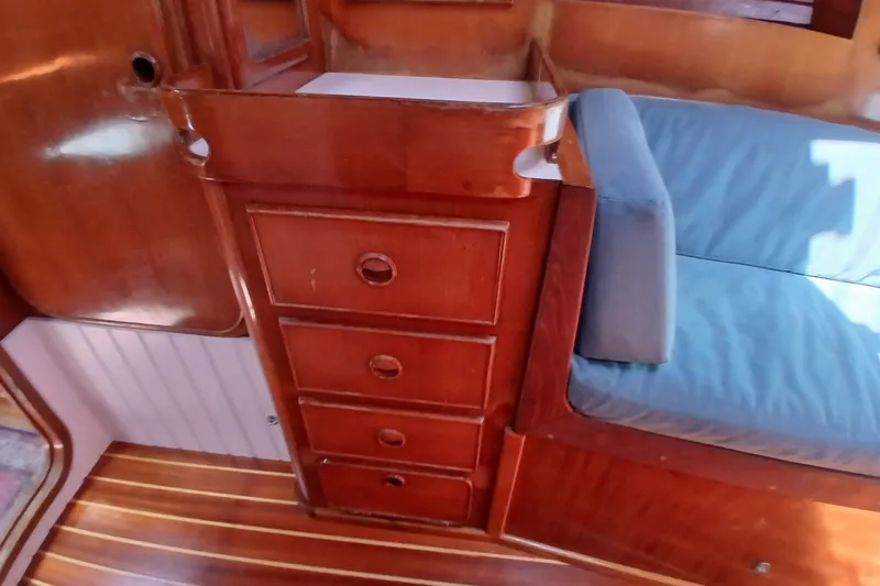 Slide: The Image of Interior of 1981 SKYE 51 yacht with wooden drawers and blue cushioned seating. - 36