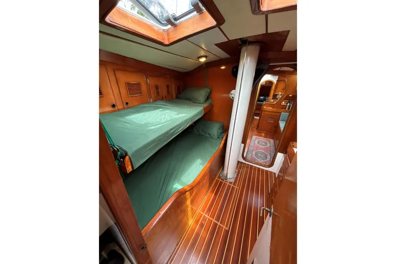 Slide: The Image of Interior of 1981 SKYE 51 sailboat with wooden bunk beds and green bedding. - 37