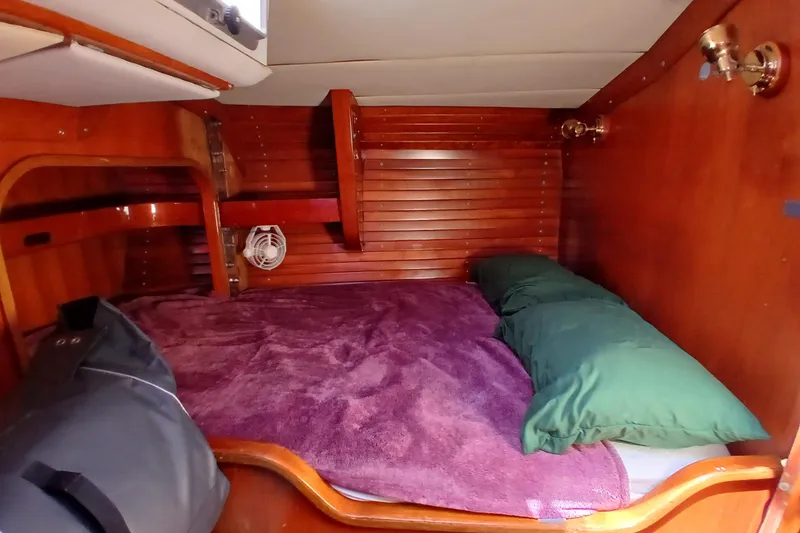 Slide: The Image of Cozy cabin interior of 1981 SKYE 51 sailboat with wooden paneling and bedding. - 48