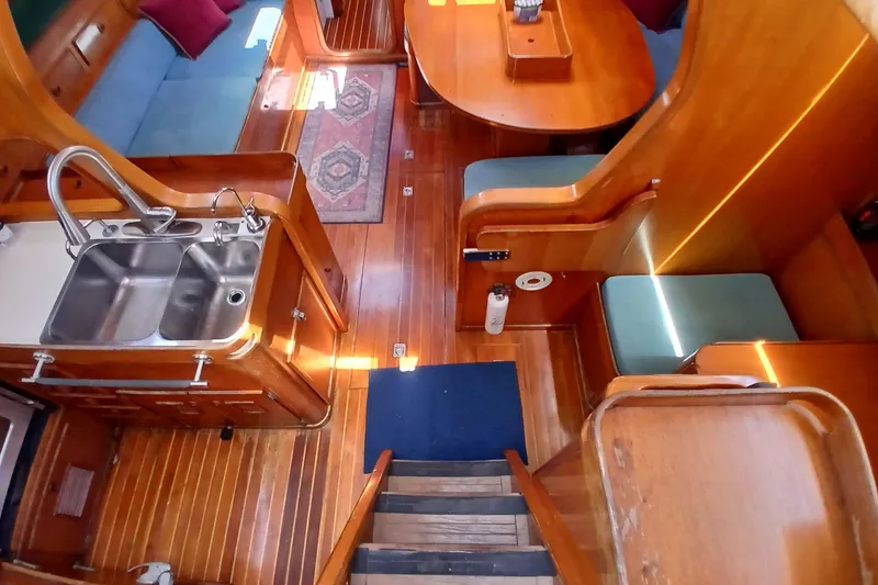 Slide: The Image of Interior of 1981 SKYE 51 yacht with wooden flooring, kitchen sink, and seating area. - 5