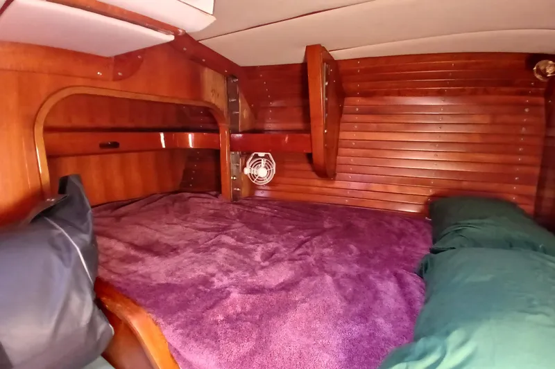 Slide: The Image of Cozy wooden cabin interior of 1981 SKYE 51 yacht with purple bedding. - 50