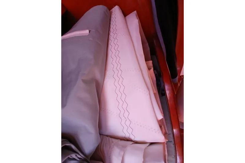 Slide: The Image of Folded sails inside a 1981 Kaufman Skye 51 yacht, showcasing intricate stitching. - 59