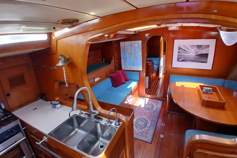 Slide: The Image of Interior of a 1981 SKYE 51 yacht with wooden decor, cozy seating, and nautical accents. - 7