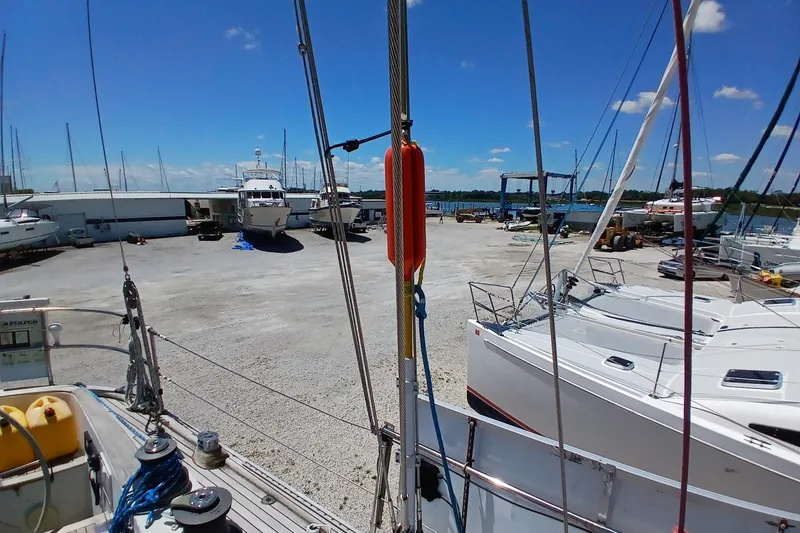 Slide: The Image of Boat yard with Kaufman Skye 51 sailboat, 1981 model, under clear blue sky. - 86