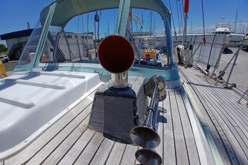 Slide: The Image of 1981 Kaufman Skye 51 sailboat deck with horn and canopy in marina setting. - 88