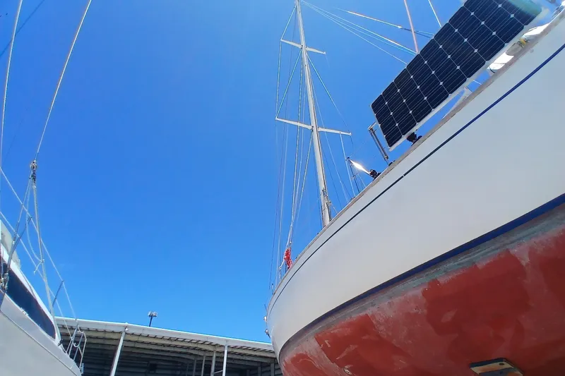 Slide: The Image of 1981 Kaufman Skye 51 sailboat with solar panels under clear blue sky. - 93