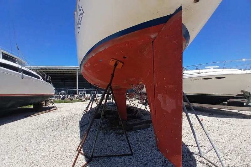 Slide: The Image of 1981 Kaufman Skye 51 sailboat on stands, hull view, in a boatyard. - 94