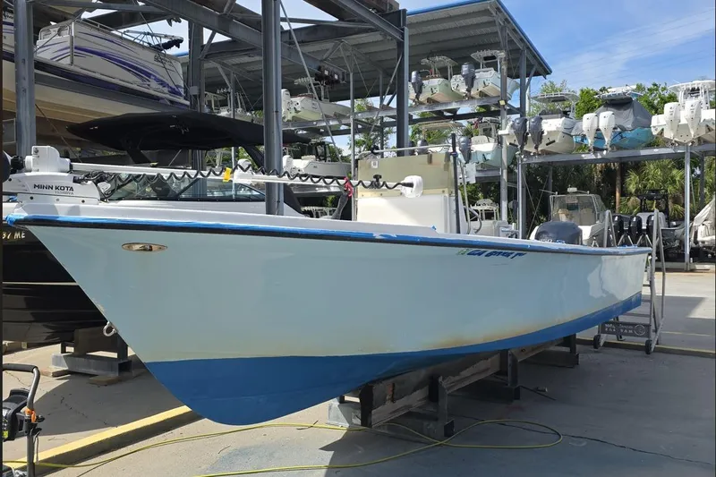 The Image of 1993 C-Hawk 25 Center Console boat on display in a marina storage area. - 1
