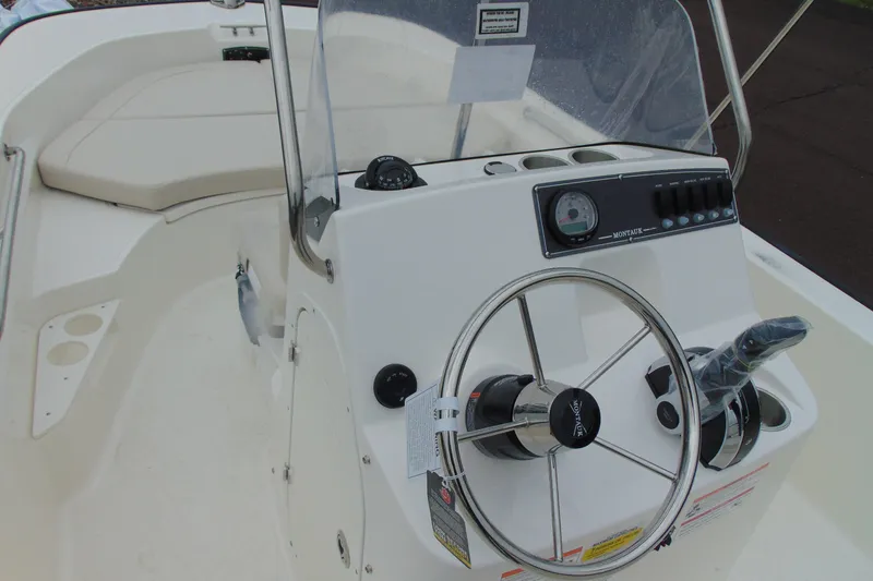Slide: The Image of 2026 Boston Whaler 170 Montauk boat console with steering wheel and controls. - 8
