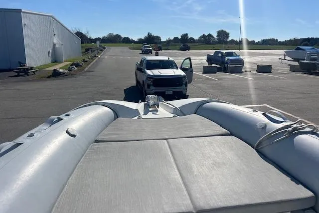 Slide: The Image of 2023 Zodiac N-ZO 680 boat on trailer in parking lot with vehicles and building. - 20