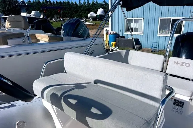 Slide: The Image of 2023 Zodiac N-ZO 680 boat with cushioned seating, docked near a blue building. - 21