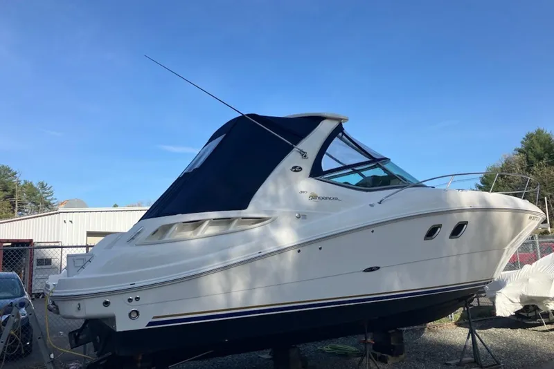 The Image of 2008 Sea Ray Sundancer 310 boat with blue canopy, docked outdoors under clear sky. - 0