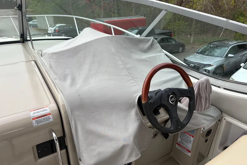 Slide: The Image of 2008 Sea Ray Sundancer 310 helm with covered dashboard and wooden steering wheel. - 13